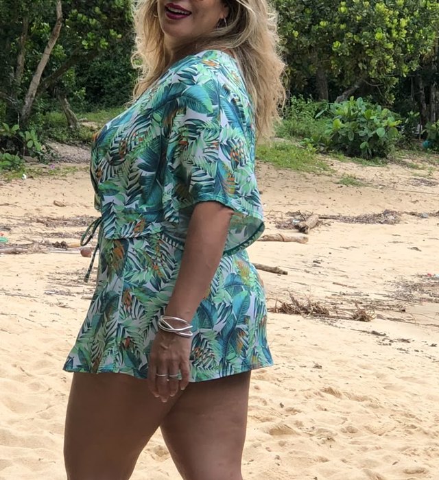 Luciana anos atrás, de vestido azul, na praia