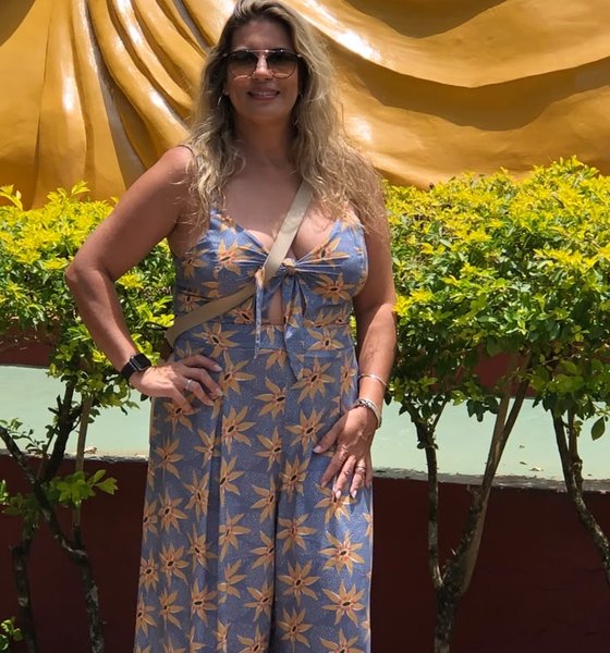 Luciana anos atrás, de vestido, em uma viagem